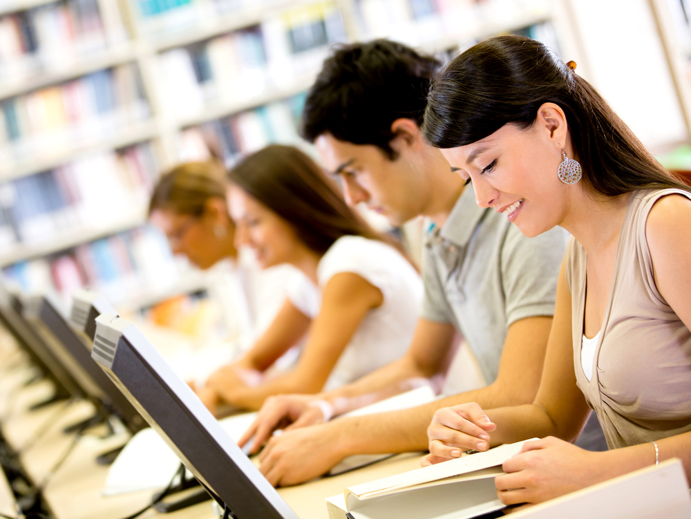 Group university ICT students using computers and smiling